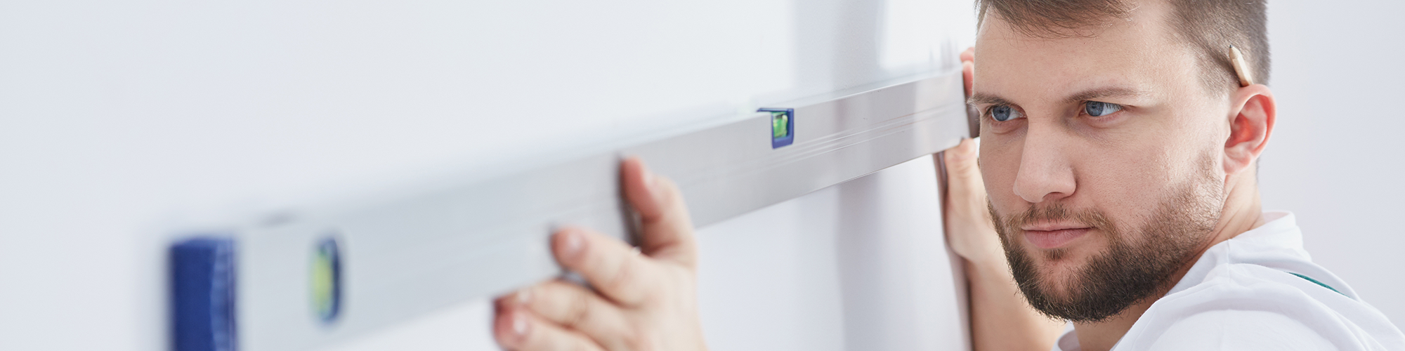 Flat Survey for a Leasehold Flat: Why you need a homebuyers survey for your flat, from SAM Conveyancing. A RICS Surveyor assesses the walls with a spirit level during a flat survey.