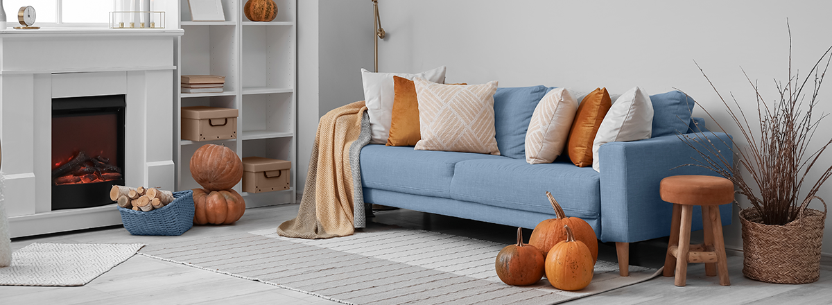 A cosy, September seasonal home, showing a sofa and fireplace dressed in pumpkins and warm autumnal colours. This is SAM Conveyancing's analysis of the housing market in September.
